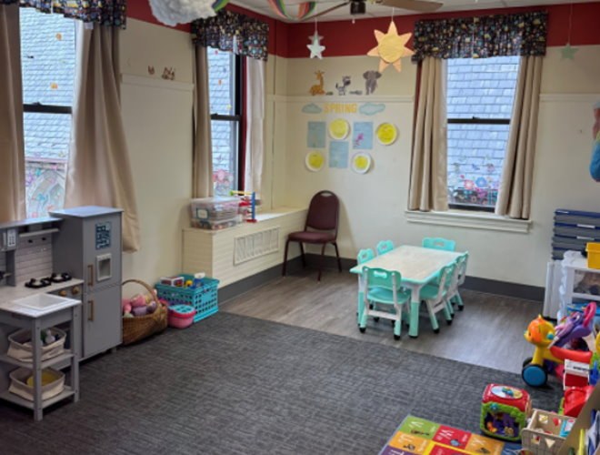 Young toddler room with a play kitchen, small table and toys